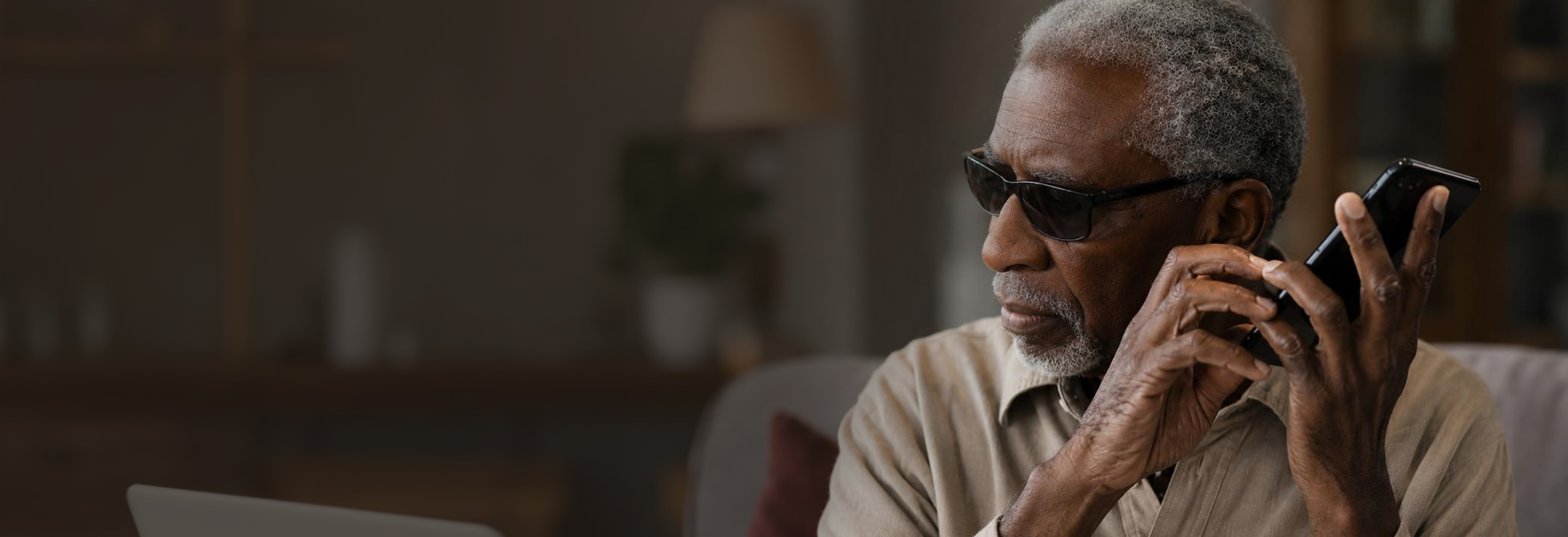 Image of a man listening to the Whatsapp Umsizi Bot on his phone
